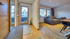 Un salon moderne avec un canapé, une table à manger et une grande fenêtre.
