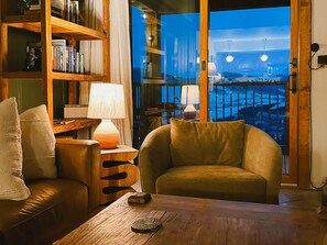 A cozy living room with a leather sofa, a wooden coffee table, and a bookshelf. - Trailside 3BR Top-Floor Views and Sauna (Crested Butte)