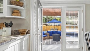 A kitchen with white cabinets, wicker baskets, and a countertop with kitchen utensils. - Parris Island 10 min - Pet friendly Home + Yard (Beaufort)