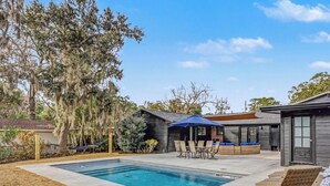 A backyard with a swimming pool, outdoor seating, and a wooden structure. - Parris Island 10 min - Pet friendly Home + Yard (Beaufort)