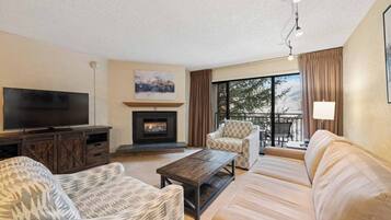 A living room with a fireplace, a television, and a sofa.