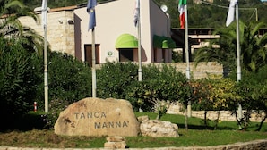 Un bâtiment doté d’une façade en pierre, d’un auvent vert et de plusieurs drapeaux.