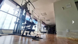 A gym with exercise equipment, large windows, and a wooden floor. - Cozy 2 Bedroom Apartment. Excellent Location! (Batista Campos Belém)