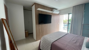 A bedroom with a bed, a TV mounted on the wall, a window with curtains, and a view of the outside. - Cozy 2 Bedroom Apartment. Excellent Location! (Batista Campos Belém)