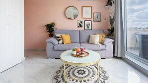 Un salon avec un canapé, une table basse et un tapis rond.