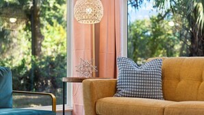 Una sala de estar acogedora con un sofá, una silla y una lámpara de pie.