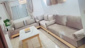 Ein Wohnzimmer mit Ecksofa, Couchtisch und einer Pendelleuchte.