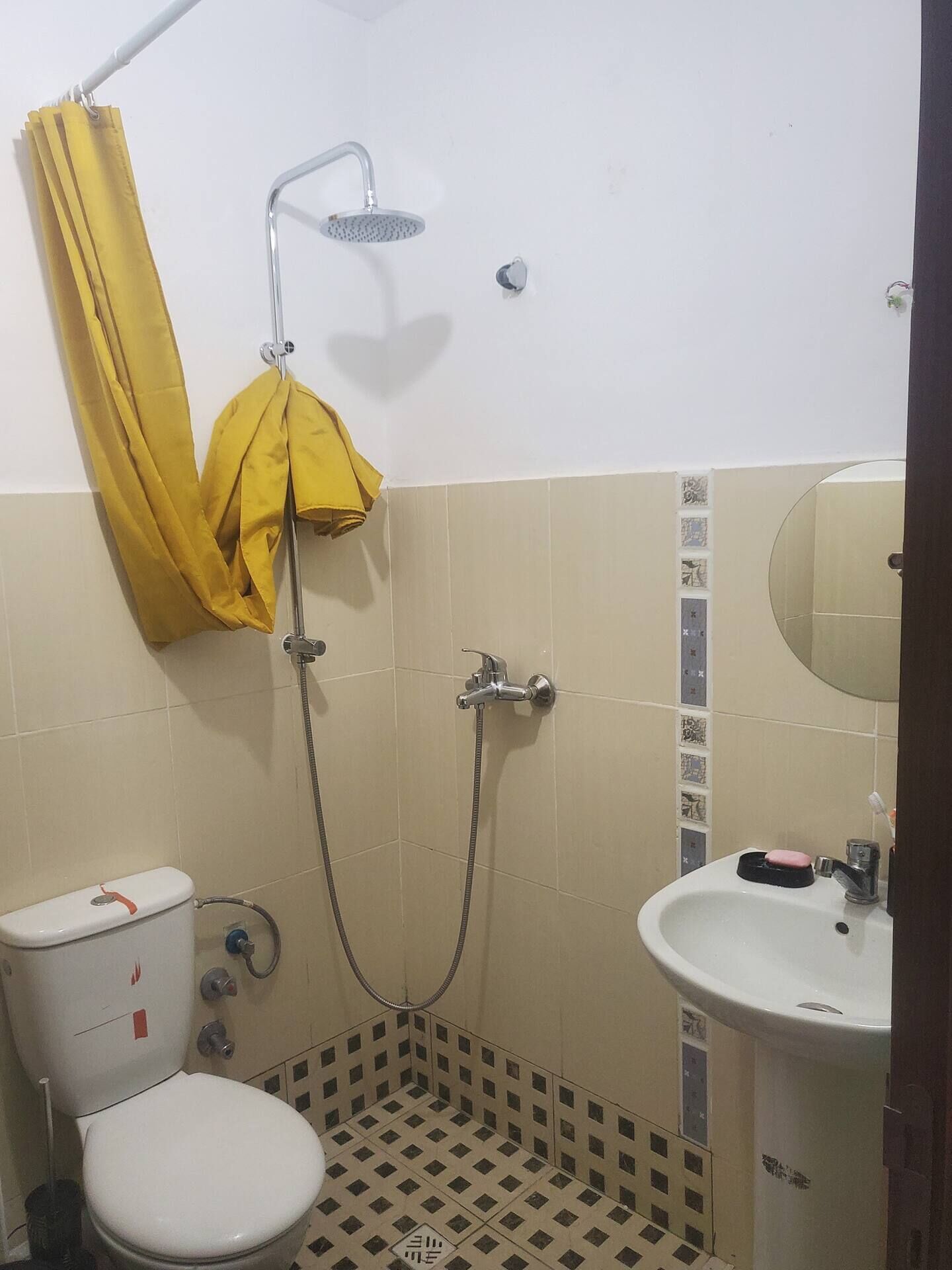 Ein kleines Badezimmer mit Toilette, Waschbecken und Dusche.