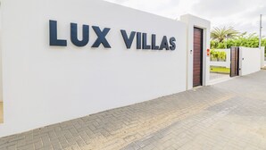 Eine weiße Wand mit der Aufschrift "LUX VILLAS" in großen, fetten Buchstaben.