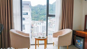 A room with two armchairs, a small table, and a refrigerator. - Ngan Ha Hotel Panorama View (Tam Dao)