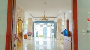 A hotel lobby with a chandelier, a reception desk, and a large water dispenser. - Ngan Ha Hotel Panorama View (Tam Dao)