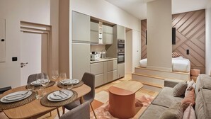 A modern apartment with a dining area, kitchen, and living space.