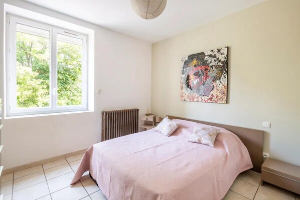 A bedroom with a bed, a radiator, a window, and a painting on the wall. - Cevennes View Retreat in Molieres (Molieres-sur-Ceze)