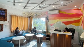 Een kamer met een receptiebalie, een zithoek en een muurschildering.