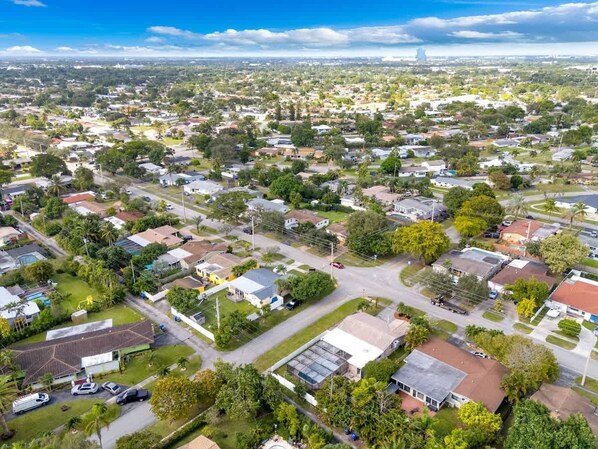 An aerial view of a residential area with houses, roads, and greenery.