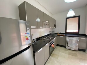 Een koelkast, een oven, een kookplaat, een koffiezetapparaat/waterkoker