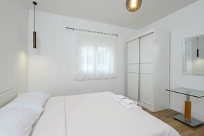 Relax in a serene space with a large bed, glass-top desk, and sliding door closet.