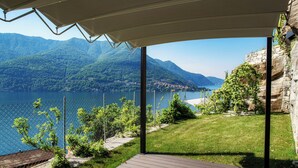 Un espace extérieur abrité offrant une vue sur un lac et des montagnes.