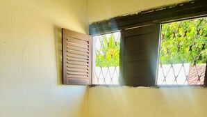 A single bed with a patterned bedspread, two pillows, and two towels folded on the bed. - Harmô Hostel Cultural (Conde)