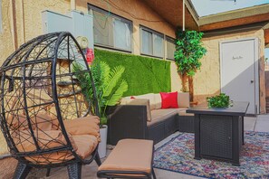 A patio area with wicker furniture, a hanging chair, a sofa with cushions, and a small table. - Private 2 Bedroom Guesthouse Near Fremont! (Las Vegas)