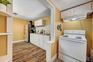 A kitchen with white cabinets, a stove, and a refrigerator. - Private 2 Bedroom Guesthouse Near Fremont! (Las Vegas)