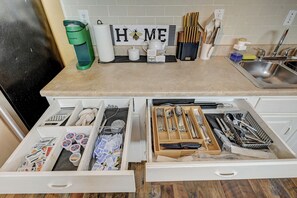 Una cuina amb una cafetera, un senyal amb la paraula 'HOME' i utensilis de cuina ordenats.