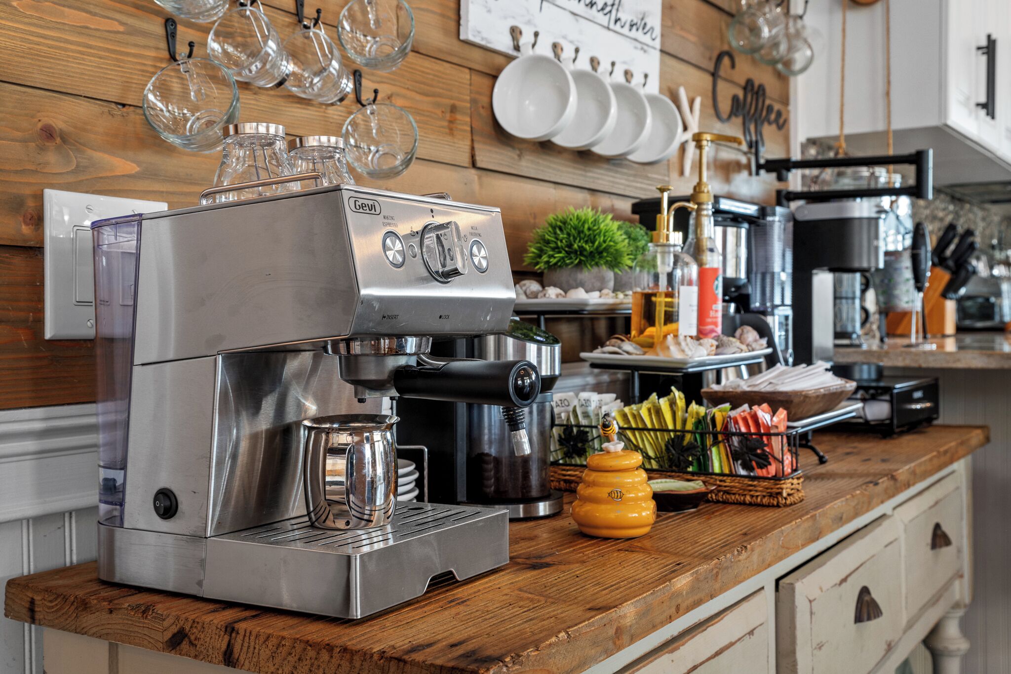 Een professionele keuken met een espressoapparaat, roestvrijstalen apparatuur en een houten werkblad.