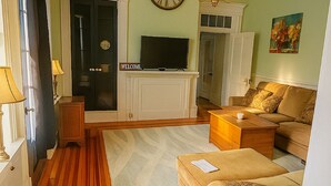 A living room with a television, sofa, and a fireplace.