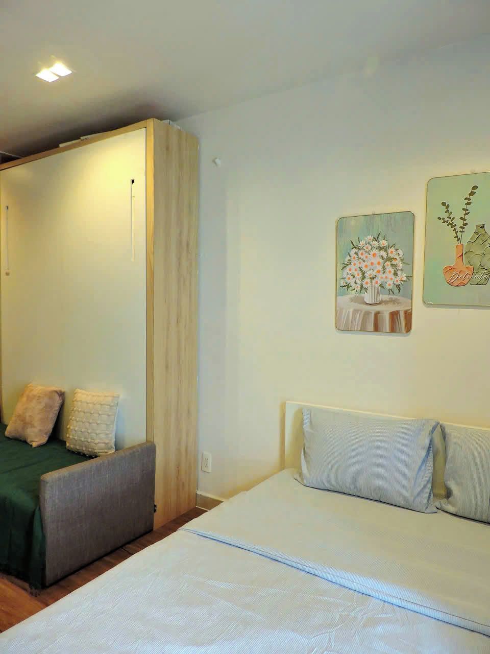 Ein Schlafzimmer mit einem Bett, einem Nachttisch, einem Sessel und einem Bild an der Wand.