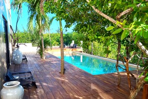 A wooden deck with a pool, surrounded by trees and greenery. - Piquete Holbox (Isla Holbox)