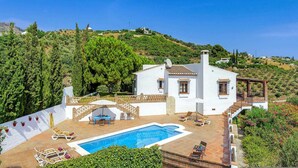 A white villa with a swimming pool, a patio with lounge chairs, and a view of a hillside. - Casa Jorge in Frigiliana (Frigiliana)