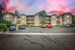 A multi-story residential building with a parking lot in front.