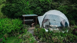 A geodesic dome tent in a lush, green forest setting. - Glampling Nubes de Monteverde (Monteverde)
