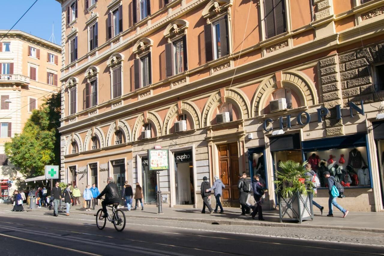 A street view of a building with a shop on the ground floor and a medical facility on the left.