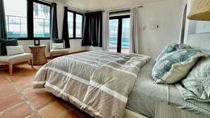 Ein Schlafzimmer mit einem großen Bett, Meerblick und einem Balkon.