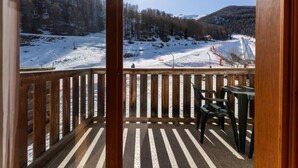 A wooden balcony with a view of a snowy mountain landscape, including ski lifts and a clear sky. - 40m from ski slopes, 1st floor, fitness, swimming pool, sauna, balcony, tv, ski locker, 40m² (Les Orres)