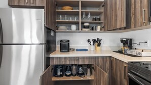A modern kitchen with wooden cabinets, stainless steel appliances, and a coffee bar area. - Modern 3BR Near Beaches–Fast WiFi & Spacious Design (Fort Lauderdale)