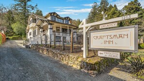 Naamplaatje van A Craftsman Inn met een bord 'Kamers beschikbaar' en een bord met 'Parkeren achter'.