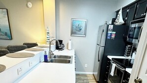 Una cucina moderna con isola centrale, elettrodomestici in acciaio inossidabile e pavimento in legno a spina di pesce.