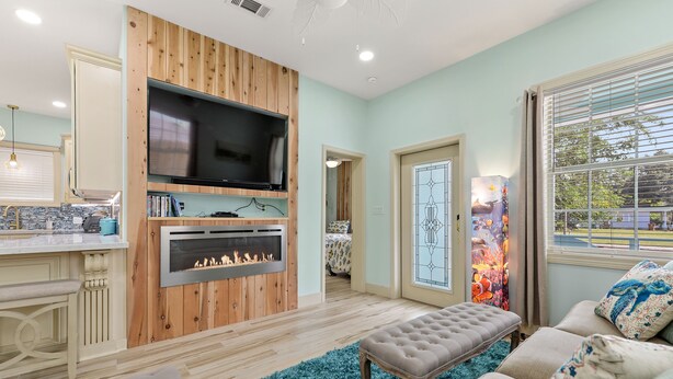 A modern living room with a fireplace, a television, and a cozy seating area.