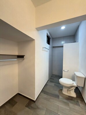 Habitación triple básica, varias camas | Baño | Tina con regadera, regadera tipo lluvia, toallas, jabón 