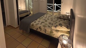 Une chambre à coucher comprenant un lit, une armoire, un miroir et un balcon avec une balustrade.
