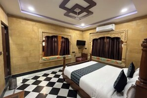 Una habitación de hotel con piso a cuadros, una cama con cabecera de madera y dos paneles decorativos en la pared.