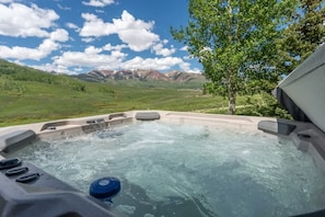 Un jacuzzi con vistas despejadas a montañas al fondo.