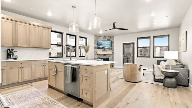 A modern kitchen with wooden cabinets, a central island, and a built-in dishwasher.