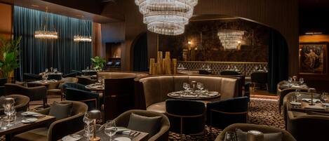 Ein Restaurant mit mehreren Tischen, Stühlen und einer großen Chandelüster.