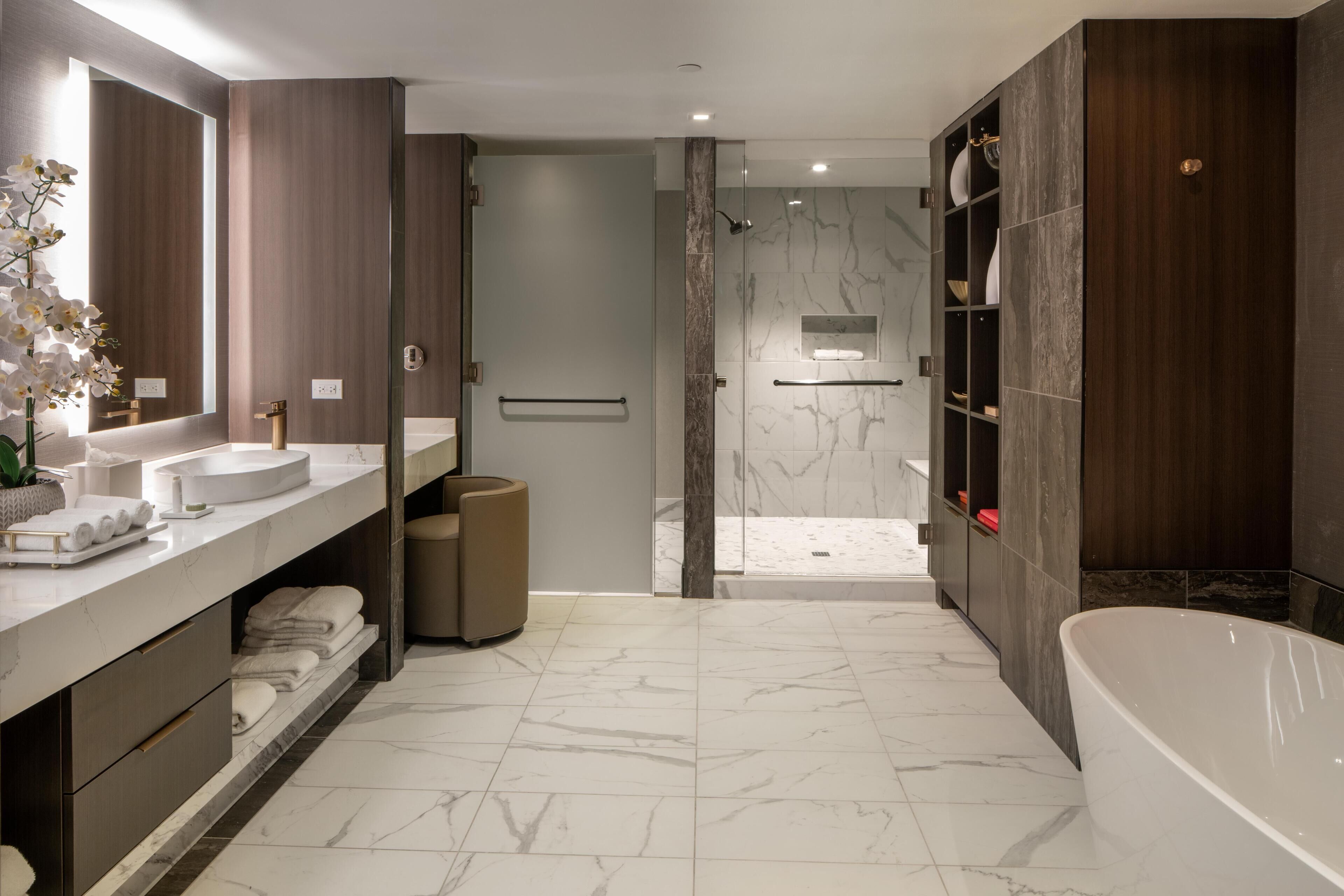 Un baño moderno con una bañera grande, cabina de ducha y tocador con espejo.