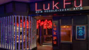 A restaurant named LukFu with a neon sign, a take-out window, and a menu board.