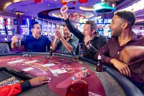 A casino gaming area with multiple slot machines and a roulette table.