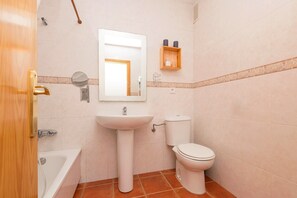A bathroom with a sink, toilet, and bathtub.
